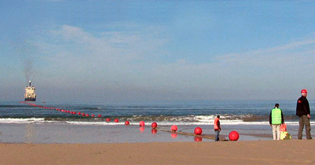 6000km to go: undersea cable-laying starts at the beach.