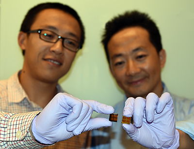 Dr Jiang (L) with MAPbI3 solar cell; Dr Wang (R) holds an iodine-degraded cell.