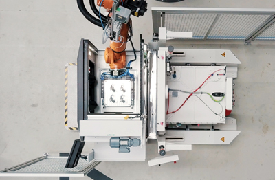 A robot removes the additively manufactured parts from the build platform.