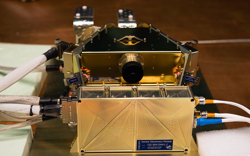 CHEOPS will be the first mission dedicated to searching for exoplanetary transits by performing ultra-high-precision photometry on bright stars already known to host planets. It has one instrument - a photometer with a single CCD, operating between 0.4 &mu;m and 1.05 &mu;m, that is at the focal plane of an on-axis Ritchey-Chr&eacute;tien telescope of 33 cm diameter.

The bronze-coloured Focal Plane Module (FPM), which houses the CCD detector array and the Front-End Electronics, is seen here mounted on the flat, black optical bench at the rear of the downward-pointing telescope tube (not seen). The FPM is the detector system that captures the image from the telescope. Image: ESA.