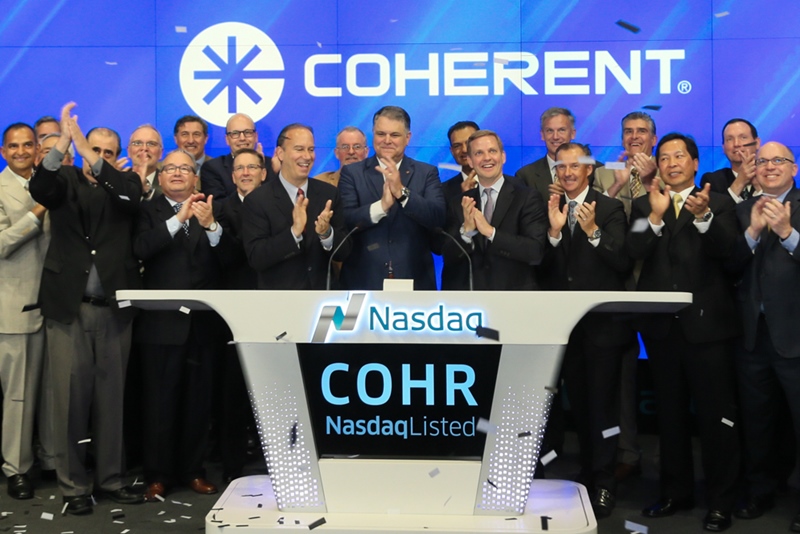 Coherent CEO John Ambroseo, seen here (center) ringing the Nasdaq opening bell back in 2016, has headed up the company for nearly 17 years. He first joined the laser giant back in 1988, and as CEO has overseen a series of significant acquisitions and sales growth. He is set to retire within two years, with a successor now being sought. Photo: Nasdaq.com.