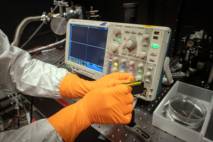 Chunxiong Bao in the laboratory with the tiny unit that can both receive and transmit optical signals. Photo: LiU / Magnus Johansson.