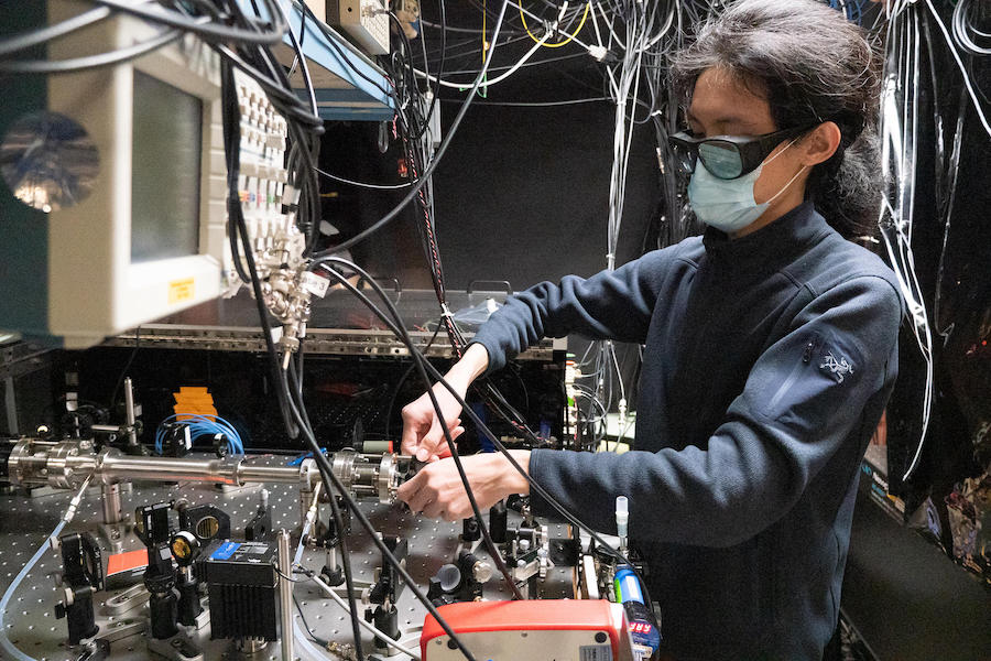Graduate student Qizhong Liang adjusts JILA's frequency comb breathalyzer, which identifies molecules associated with disease based on colors and amounts of light absorbed inside the tube (left) containing breath samples. Credit: R. Jacobson/NIST