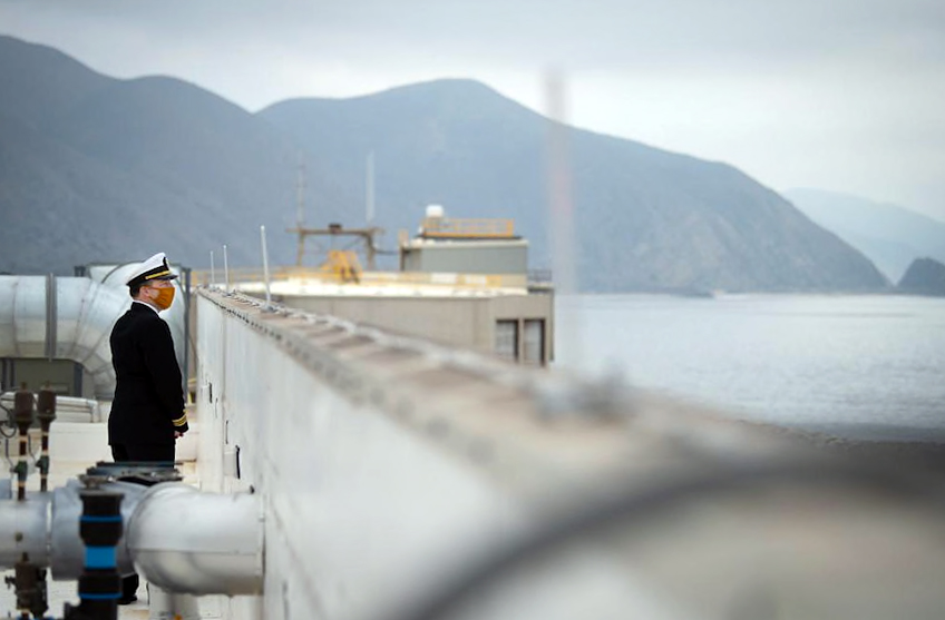 On watch: Ship Defense & Expeditionary Warfare Department Officer Lt. Cmdr. Levi Jones peers over the roof of the Directed Energy Systems Integration Laboratory (DESIL) toward the Pacific Ocean as he toured DESIL with other invited guests following its grand opening ceremony on Dec. 3 at Naval Base Ventura County, Point Mugu. (U.S. Navy Photo by Eric Parsons)