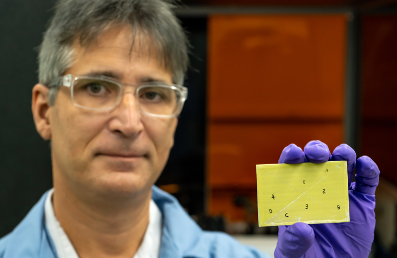 Adrian Sabau holds a primer-coated specimen, which was pretreated with a laser-interference structuring technique and shows coating adhesion. Credit: Carlos Jones/ORNL, U.S. Dept. of Energy.