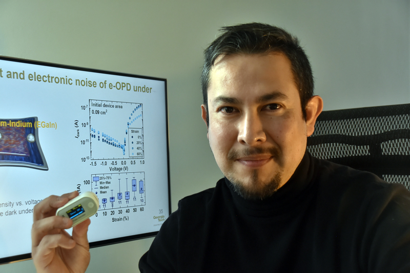 Prof. Canek Fuentes-Hernandez sees a great potential to use high-performance soft and stretchable photodetectors to enable pulse oximeters, like the one he is holding in his hand, to become more ergonomic and to consume less power. Photo credit: Canek Fuentes-Hernandez.