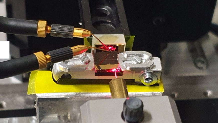 A red alignment laser was used to visualize the beam path from the fiber into the optical waveguide and its reflection at a gold mirror. Two microprobes were used to contact the photoconductor, the size of which is in the subwavelength range. Credit: Empa.