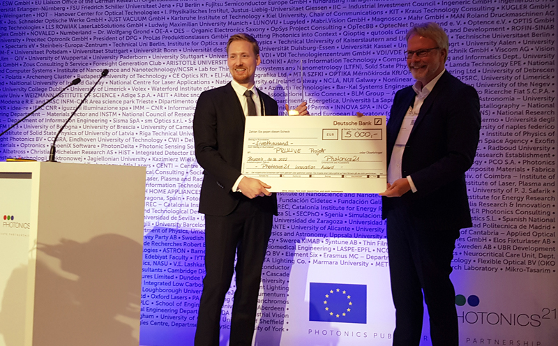 PRUUVE's Tim Achenbach was presented with the prize and a check for 5000 euros by Photonics21 President Dr. Lutz Ashke. Photo: Matthew Peach, optics.org.