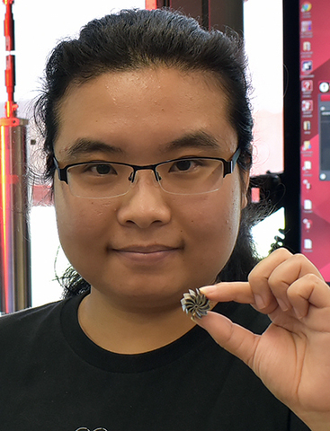UMass Amherst Ph.D. student Jie Ren holds a miniature heatsink fan, one of the 3D printed high-entropy alloy components made in Wen Chen's lab. The microstructure's atomic rearrangement gives rise to ultrahigh strength as well as enhanced ductility, research by UMass Amherst and Georgia Tech shows.
