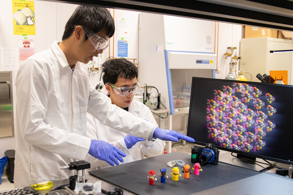 Weijian Yang and Feng Tian developed a camera that uses a thin microlens array and new image processing algorithms to capture 3D information about multiple objects in single exposure. The raw sub-images from the microarray are displayed on the monitor. Credit: Savannah Luy/University of California, Davis.