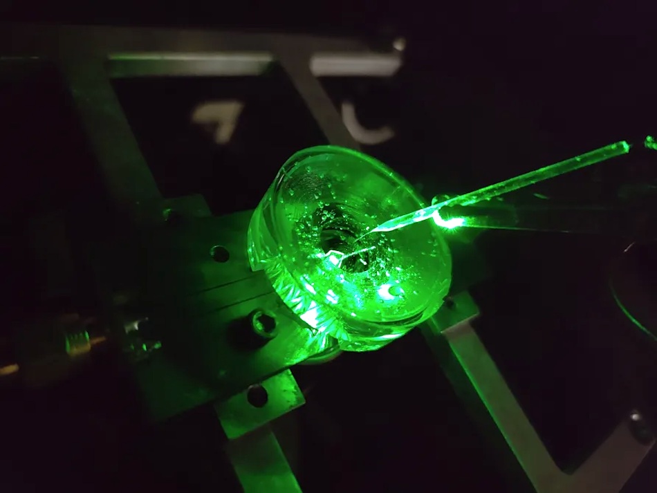 A prototype of a diamond voltage imaging microscope constructed by physicists at the University of Melbourne. A tiny electrode is suspended above the diamond chip to test the performance of the device. A green laser shone from below provides fluorescence excitation to the chip. Credit: University of Melbourne.