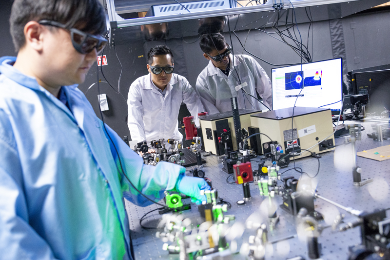 Researchers team: L-R, Research fellow Dr Deng Ang, Nanyang Assistant Professor Chang Wonkeun and senior research fellow Dr Trivikramarao Gavara from NTU Singapore's School of Electrical and Electronic Engineering with the experimental set-up used to generate intense and ultra-fast mid-infrared lasers.&ccedil;