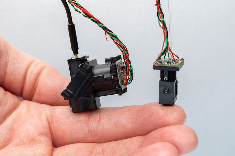 Salk researchers developed two wearable microscopes to image cellular activity in previously inaccessible regions of the spinal cord of moving mice in real-time. Credit: Salk Institute.