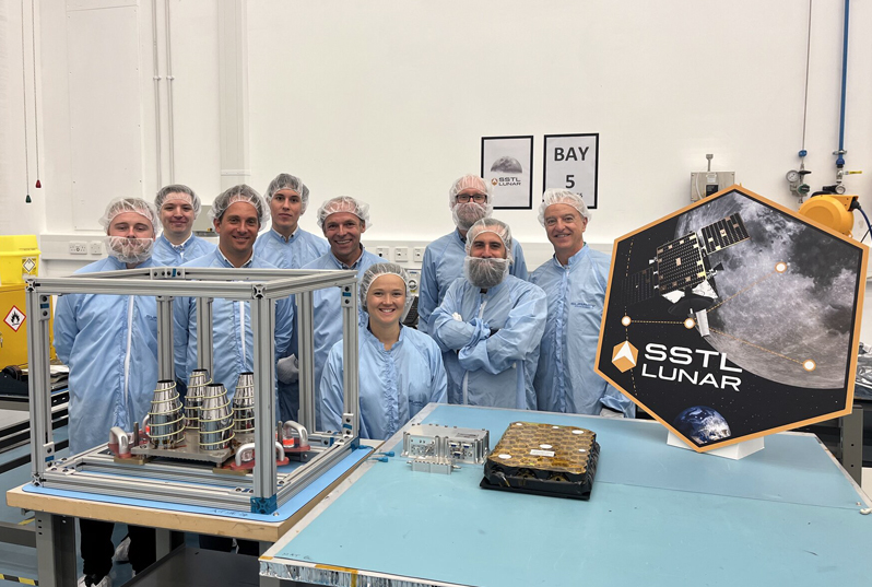 The complete Navigation payload (pictured) includes a four helix antenna (left, in the glass box) developed by MDA in Canada, plus the NaviMoon satnav receiver (middle, on table) from Swiss company SpacePNT, and the low noise amplifier developed by EECL in the UK. Photo: ESA.