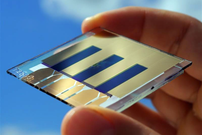 The organic solar cell with an efficiency of 15.8 percent set a new world record.  Applying anti-reflection coating allows more light to be absorbed in photo-active layer. The photo shows the record cell in a group of three cells. &copy; Fraunhofer ISE.