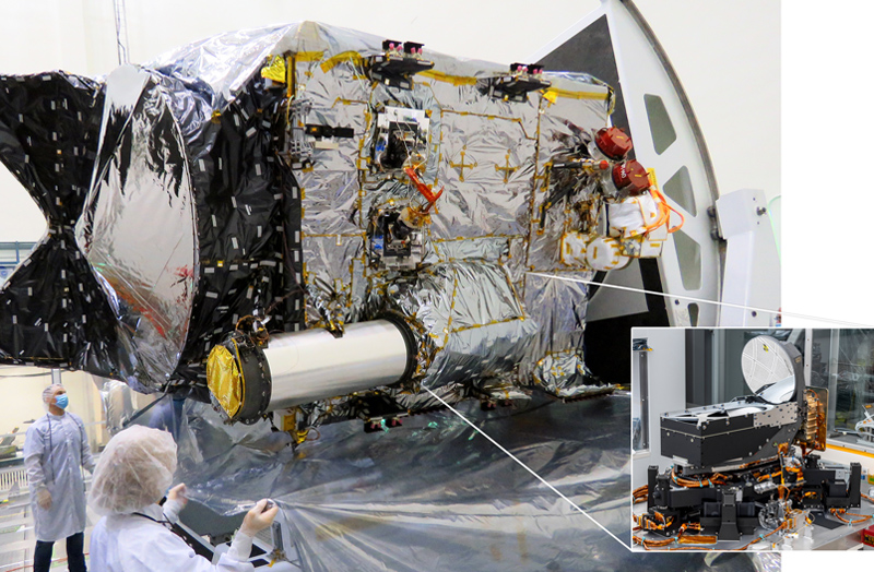 The Deep Space Optical Communications (DSOC) flight transceiver is inside a large tube-like sunshade and telescope on the Psyche spacecraft, as seen here inside a clean room at JPL. An earlier photo, inset, shows the transceiver assembly before it was integrated with the spacecraft. Credits: NASA/JPL-Caltech.