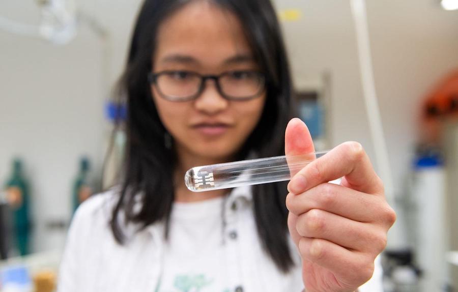 UChicago researcher Xingyu Shen holds a device that uses quantum dots to produce infrared light, a scientific advance that could lead to new lasers or sensors. Credit: Jean Lachat/UChicago. 