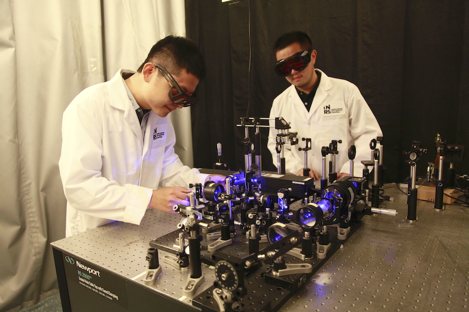 Researchers developed a diffraction-gated real-time ultrahigh-speed mapping (DRUM) camera that can capture a dynamic event in a single exposure at 4.8 million frames per second. Pictured are researchers Xianglei Liu and Jinyang Liang working on the optical setup. Credit: Xianglei Liu and Jinyang Liang/INRS. 
