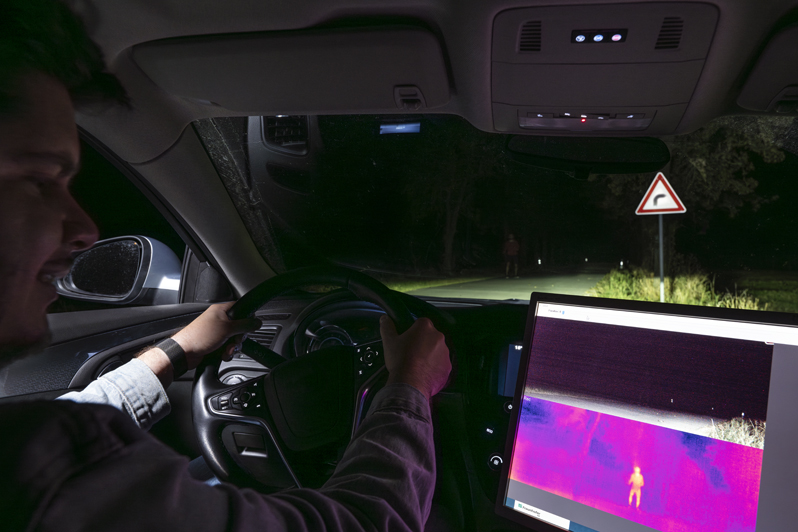 The camera in action: Despite the headlights, the pedestrian at the side of the road is barely visible. Only the thermal imaging camera makes him clearly visible. &copy; Fraunhofer IOF.
