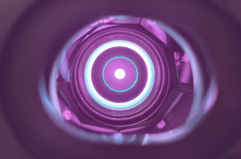 A peek inside the record-breaking laser. The image shows the round amplifier disk, through which the laser beam passes several times (bright spot at the center). Image: Moritz Seidel / ETH Zurich.
