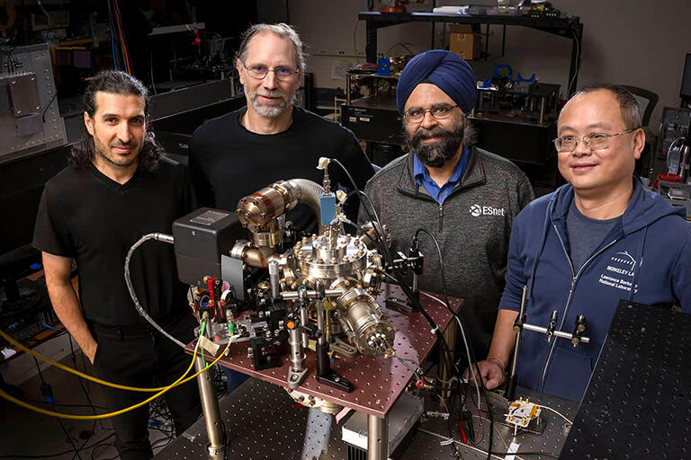 Confernce highlight: Quant-Net researchers Erhan Saglamyurek, Hartmut H&auml;ffner, Inder Monga and Wenji Wu demonstrate their ion-trap quantum processor, a key subsystem in the network testbed connecting H&auml;ffner's UC Berkeley physics lab to Berkeley Lab. Photo: Quant-Net  / Berkeley Lab.