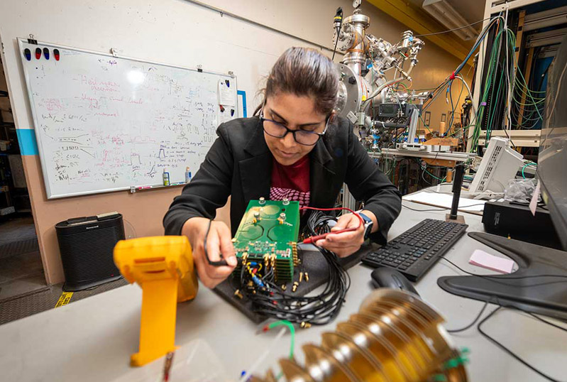 Kaushalya Jhuria in the lab testing the electronics that are part of the experimental setup used for making qubits in silicon. Credit: Thor Swift/Berkeley Lab.