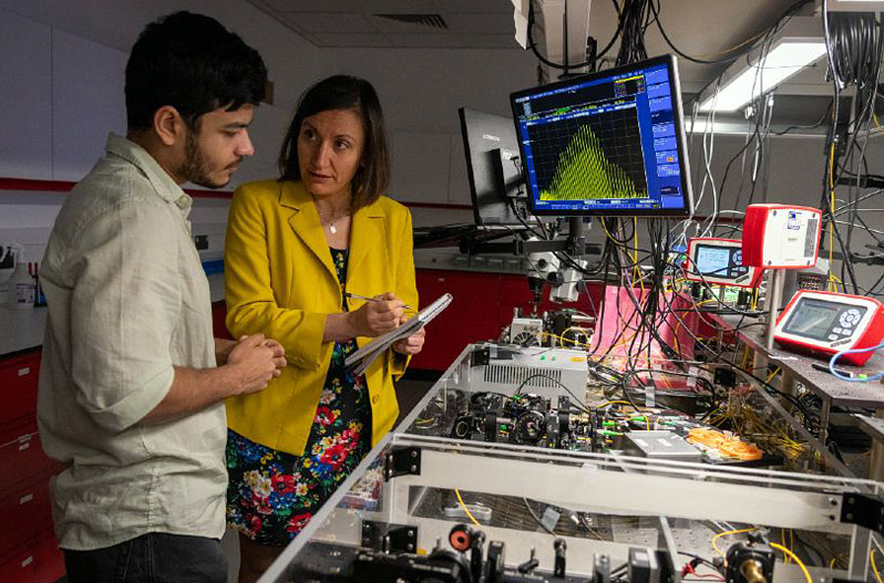 The Emergent Photonics Research Centre is home to a team of researchers focused on advancing ultra-fast nonlinear optics, complexity, and photonics knowledge. Pictured from right to left is Professor Alessia Pasquazi, Professor of Nonlinear Optics, and PhD student Debayan Das. Image courtesy of hollisphotography.uk.