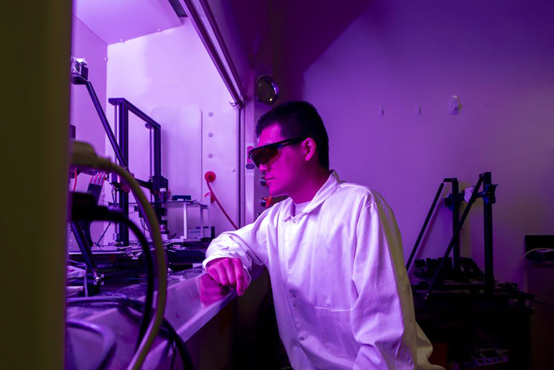 Doctoral student Bujingda Zheng uses a 3D printing and laser process to manufacture multi-material, multi-layered sensors, circuit boards and textiles with electronic components. Photo: Sam O'Keefe, University of Missouri.