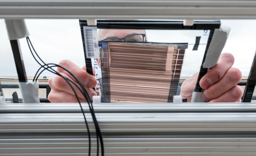 Tim Silverman installs a PACT minimodule at the Outdoor Test Facility at NREL. Photo by Werner Slocum, NREL.