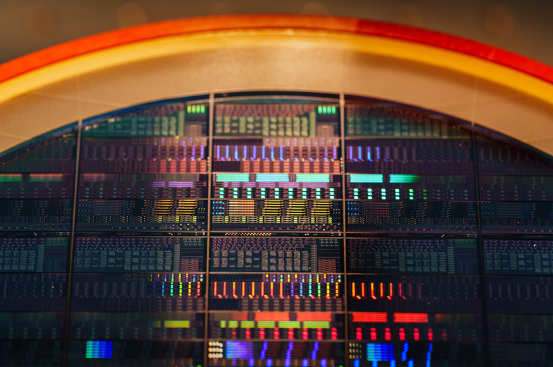 Sandia National Laboratories is collaborating with Arizona State University to advance how light can carry quantum information. Instead of using typical large optical tables, Sandia is developing acousto-optic device technologies, such as the eight-inch wafer above, that can selectively reflect different colors of light. Photo by Craig Fritz.