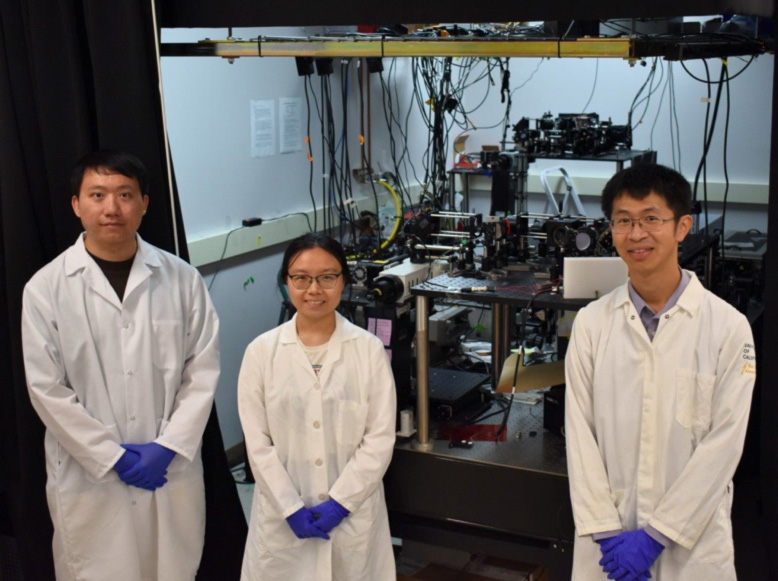 Weijian Yang (right) with graduate students Shu Guo (left) and Yunyang Li (middle) in front of the new two-photon microscope. Credit: Molly M Bechtel, University of California, Davis.