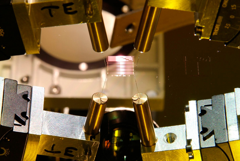 In the SmaraQ project, QUDORA Technologies, AMO and Fraunhofer IAF develop UV waveguides and photonic components based on aluminum nitride and aluminum oxide that integrate directly onto ion-trap chips. &copy; AMO GmbH.