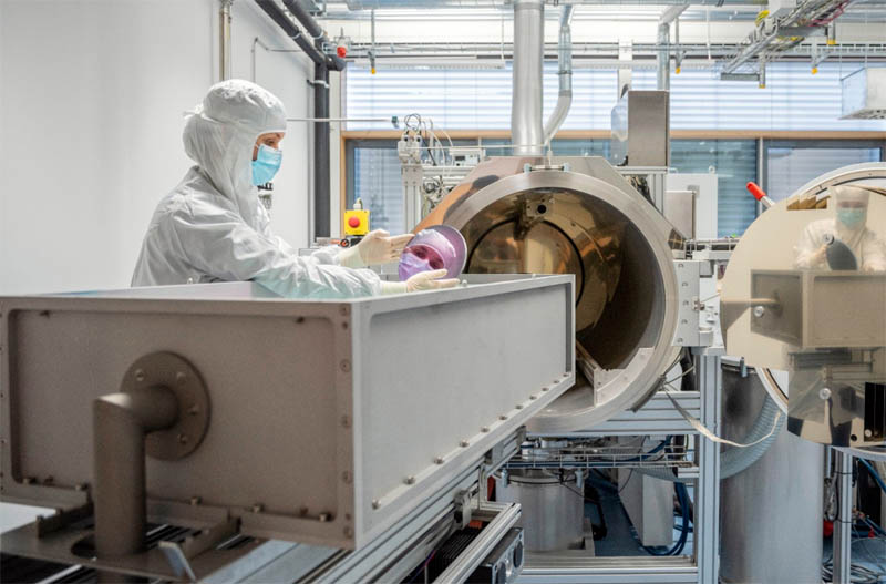 A researcher holds a highly reflective mirror for laser applications. The technology is to be optimized for laser fusion. &copy; Fraunhofer IOF.