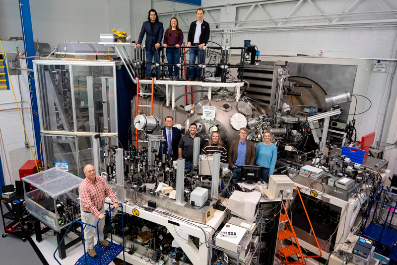 Just doing it: Members of the Laser Plasma Branch at the U.S. Naval Research Lab join visitors from fellows defense research agencies for a group photo in the NIKE target area in Washington, D.C., last October. The visit featured a tour of the NIKE laser facility to promote potential collaborative experiments in reactive materials research. U.S. Navy photo: Sarah Peterson.