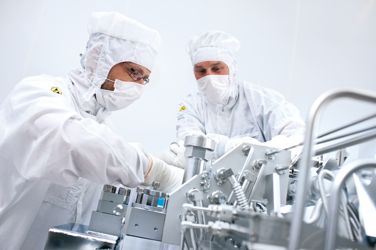 ASML engineers working on the company's pilot EUV lithography tools. Production EUV systems are now being assembled, and set to ship by the end of this year. They will most likely feature Cymer EUV sources, although Gigaphoton is aiming to make a move with its own commercial products operating at a higher conversion efficiency. Credit: ASML