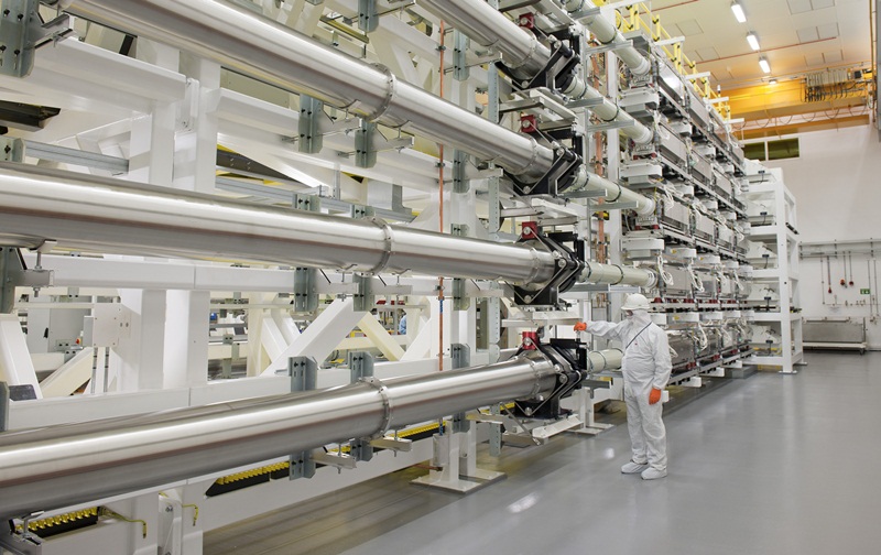 Orion long-pulse beamlines in Laser Hall: An engineer stands next to a bank of 5 of Orion's 10-nanosecond duration 