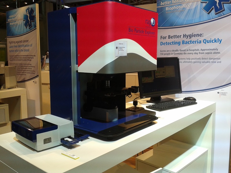 The options for rapid detection of sepsis are varied, with two potential photonics-based solutions appearing at the Laser 2015 show. Far left is Qiagen's relatively simple but portable and fast biomarker detector, which uses colorimetric or fluorescence techniques, next to the much larger and more complex Raman system called 