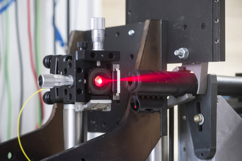 KIT's experimental set up to demonstrate ultrarapid distance measurement. The barrel of a rifle is firmly clamped and the laser beam (invisible in the experiment) is directed towards the trajectory of the projectiles fired. (Photo: Laila Tkotz, KIT)