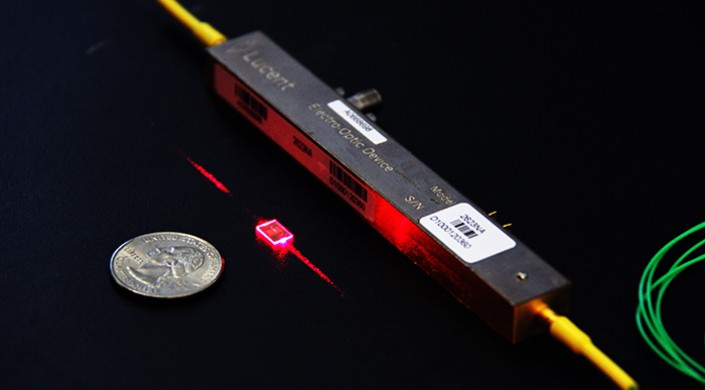 Conventional lithium niobite modulators [black, right] are the backbone of modern telecommunications but are bulky, expensive and power hungry. This integrated, on-chip modulator [red, center] is 100 times smaller and 20 times more efficient. Image courtesy of the Loncar Lab/ Harvard SEAS.