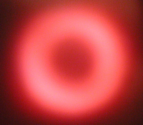 Radially polarized beam produced using an active fiber and a converging Brewster axicon
