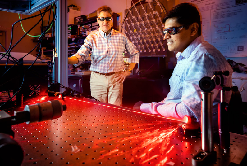 Prasad Iyer, right, and Igal Brener demonstrate optical hardware for beam steering tests.