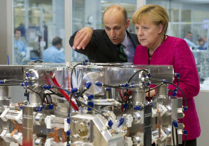 Peter Leibinger describes a laser resonator to Chancellor Merkel.