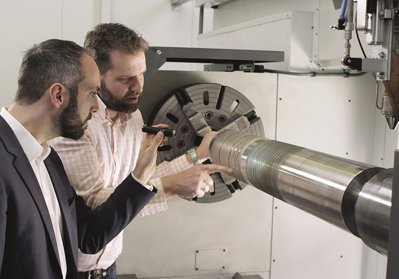 Thomas Schopphoven and IHC's Andres Veldman inspect an EHLA-treated cylinder.
