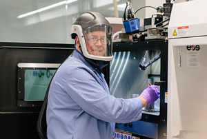 Raytheon technician operates a 3D printing machine. 