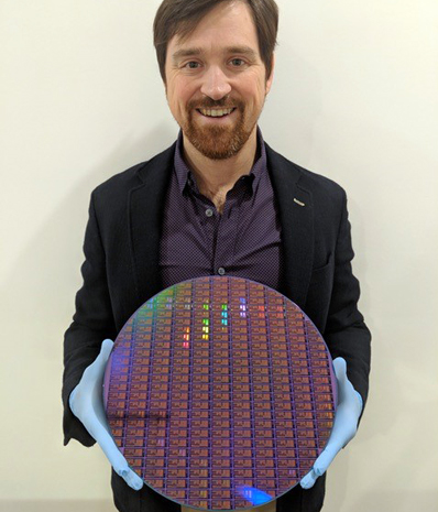 Dr. Chad Husko, CEO and founder of Iris Light tech, with a 300 mm silicon wafer.