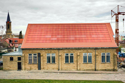 Historic building in Eppingen with a red roof-integrated PV system.